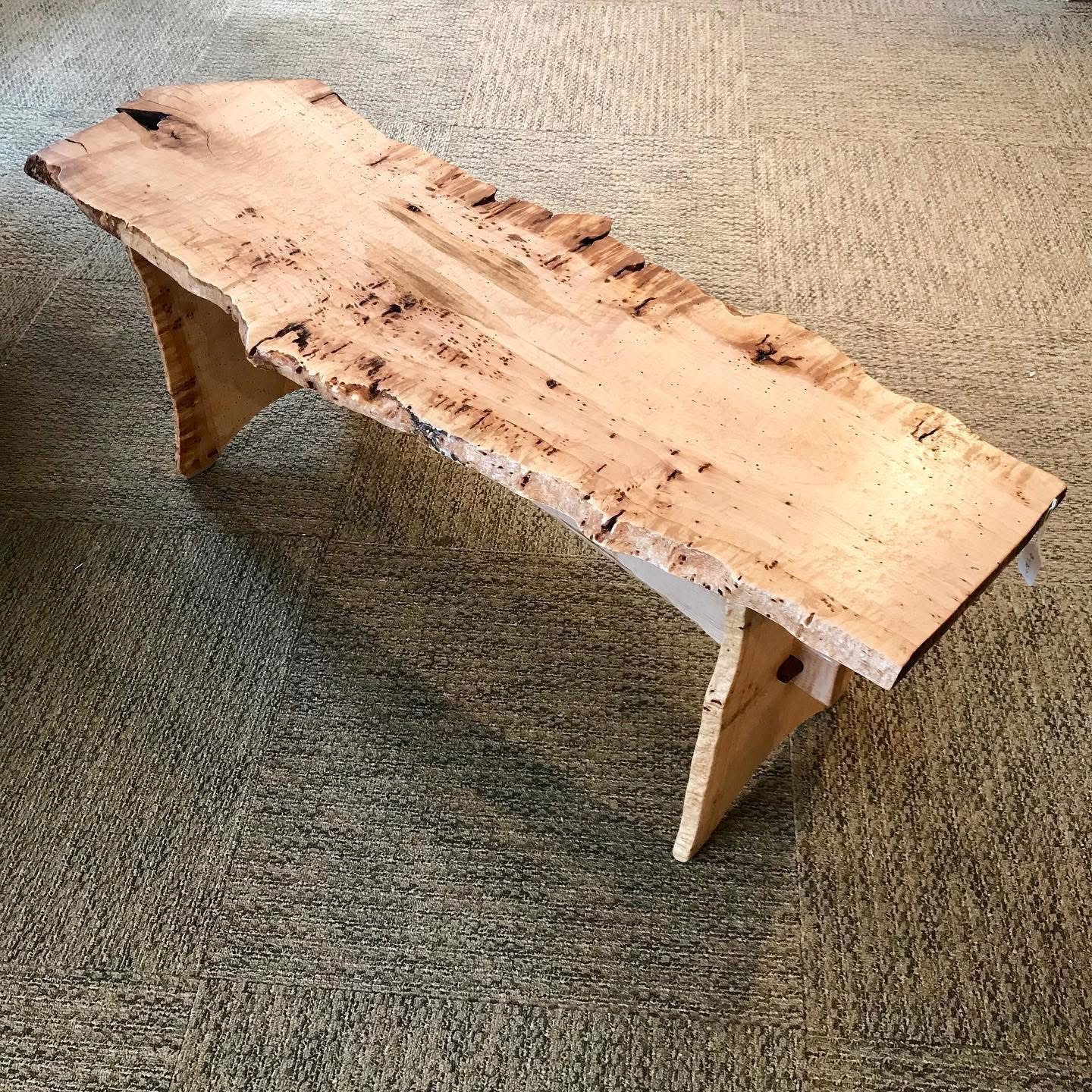 Bench made of a live edge maple slab with wooden maple legs