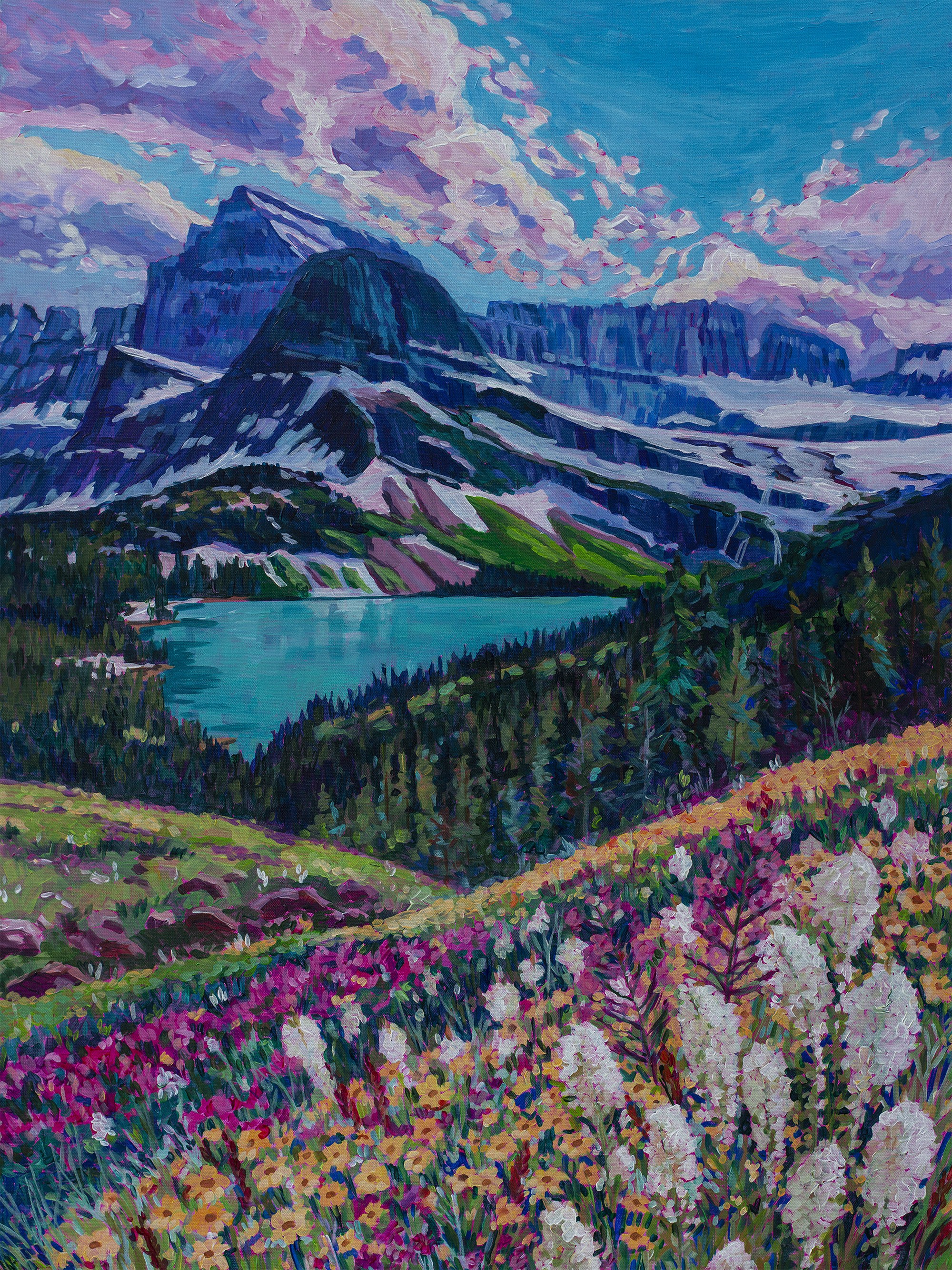 Flowers in the foreground, background is trees, alpine lake and mountains with some snow on them, Glacier National Park, Montana